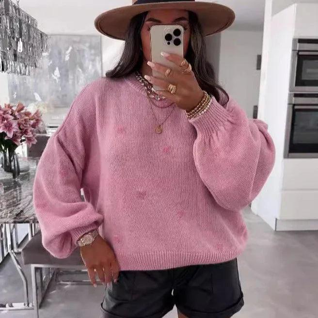 Pink oversized knit sweater with balloon sleeves, styled with black shorts and wide-brim hat for cozy everyday wear