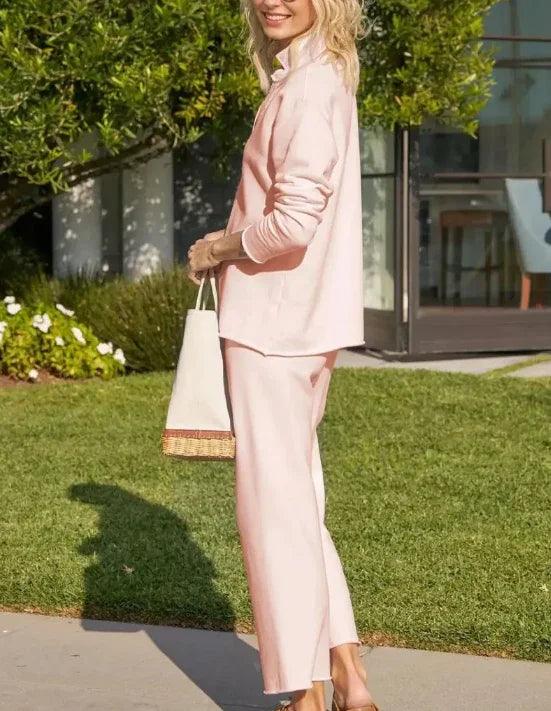 Woman in soft pink lounge set with wide-leg pants, holding woven tote bag outdoors