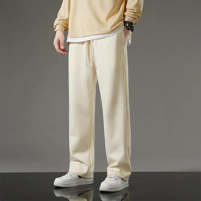 Cream wide-leg sweatpants with drawstring waist, paired with white sneakers for casual comfort wear