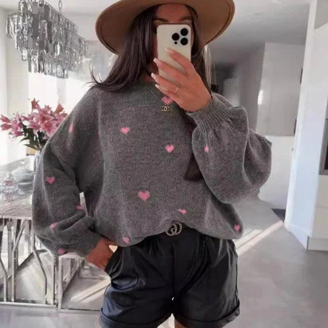 Gray heart-print sweater with puff sleeves, black shorts, and wide-brim hat for stylish comfort wear