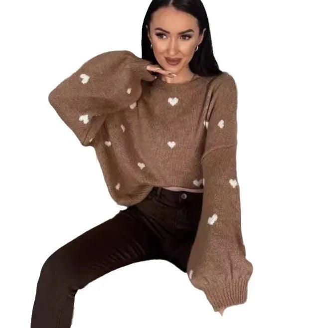Woman wearing cozy brown heart-patterned sweater with balloon sleeves, styled with dark jeans for everyday comfort.