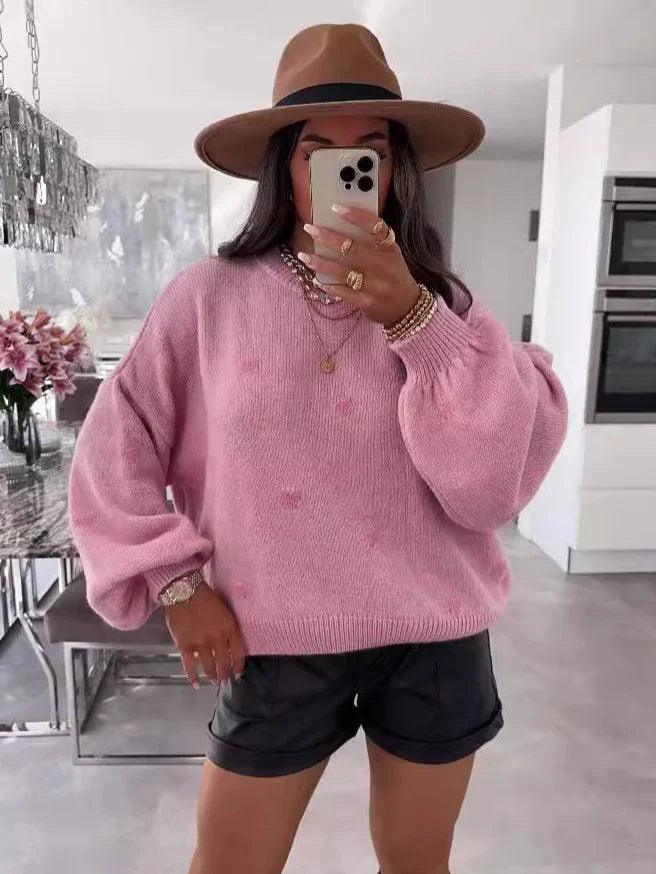 Pink oversized knit sweater with puff sleeves, paired with black shorts and a brown fedora hat for cozy style.